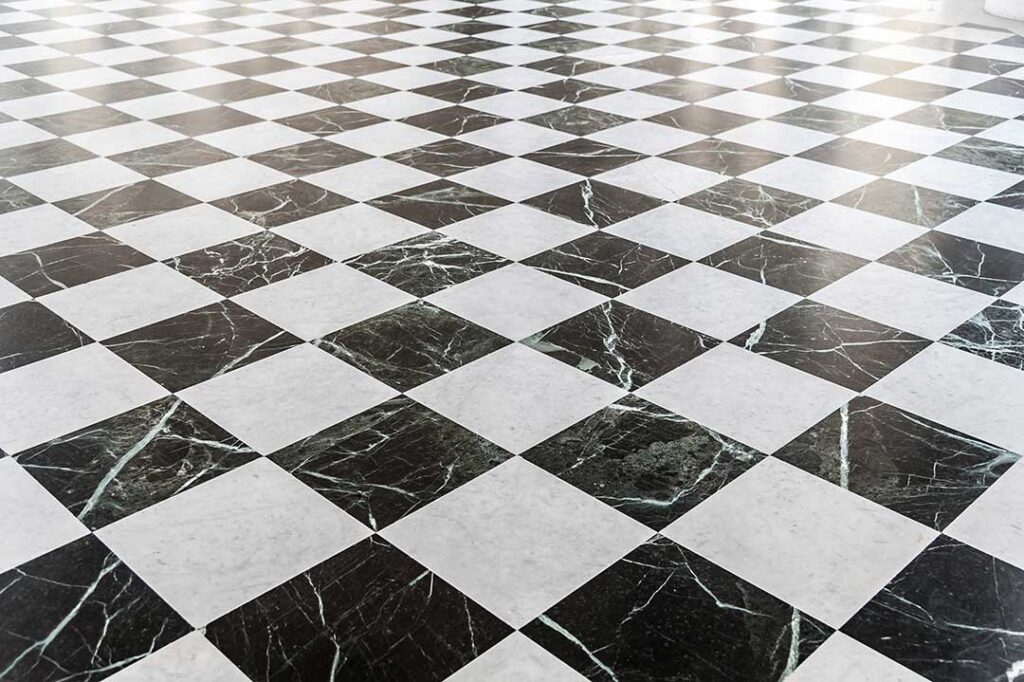 A living room floor partially covered with hardwood and partially covered with laminate, showing the difference between the two.