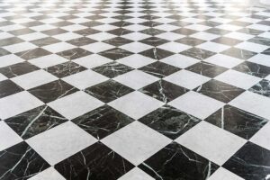 A living room floor partially covered with hardwood and partially covered with laminate, showing the difference between the two.